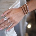 mano de mujer con pulseras y anillos de diamantes
